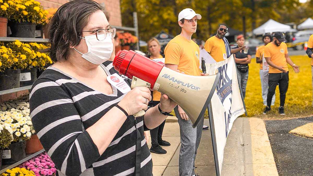 union members protesting with a megaphone outside of Mom's Organic Market