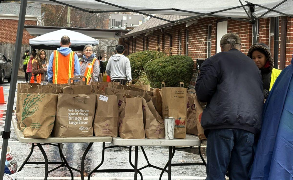 The College Park Community Food Bank, which operated out of the Church of the Nazarene on Rhode Island Avenue for 16 years, has moved. Shown, volunteers distribute groceries and turkeys before Thanksgiving. Photo by SAMMY LIU
