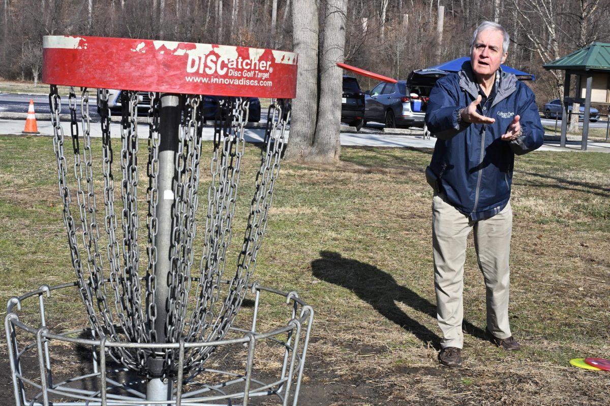 Disc golf fan Jerry O’Neil tosses a disc into a basket at the Calvert Road Park
disc golf course. Photo by AYLIN AARHUS