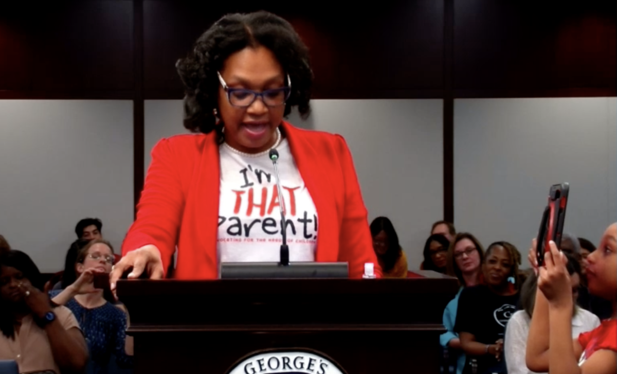 Teresa Smith, a parent, testifies in favor of increased school funding, as her daughter films her testimony.